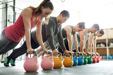 Gym class doing push-ups on kettlebells