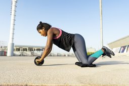 Woman doing a core workout with an ab wheel