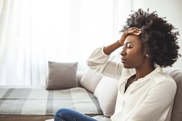 woman with calorie deficit headache with her hand on her head