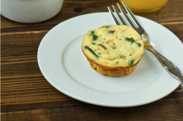 A spinach ricotta quiche muffin on a white plate