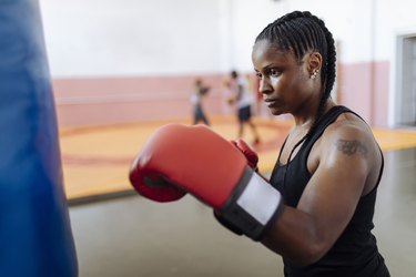 Person wearing a black tank top wearing boxing gloves.